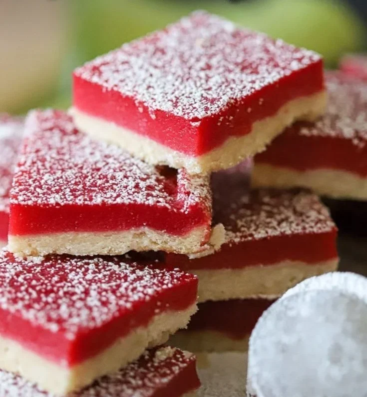 Homemade cranberry lemon bars with a citrusy glaze on a white plate