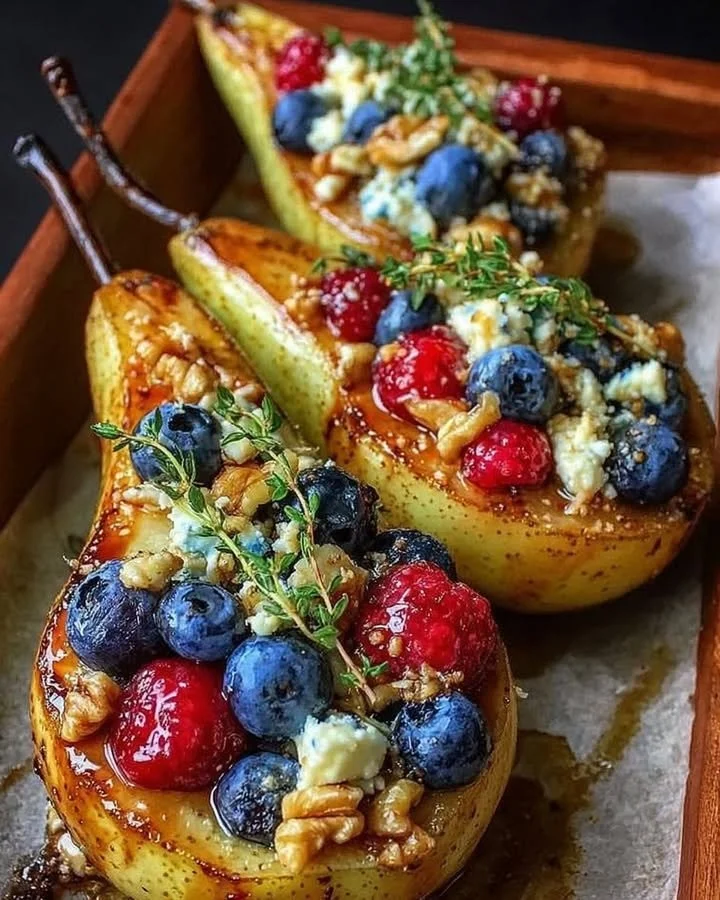 Baked pears topped with berries, honey, walnuts, and blue cheese