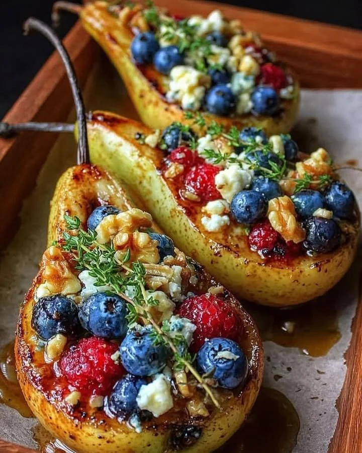 Baked pears with berries, honey, walnuts, and blue cheese on a plate.