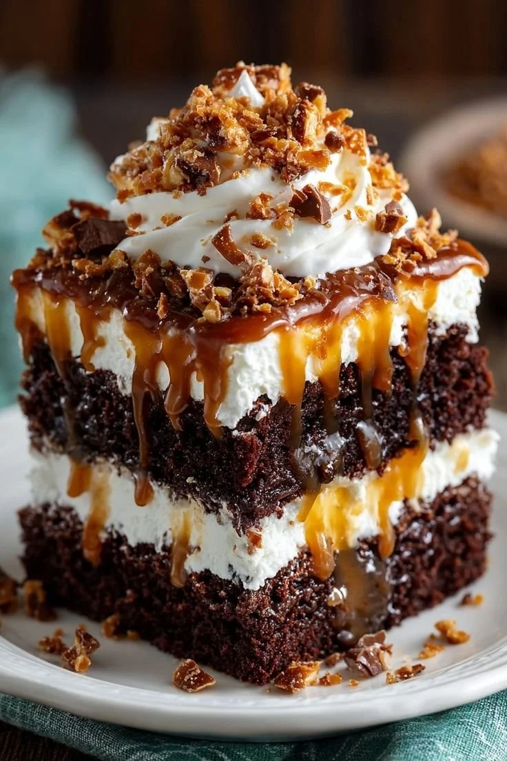 Sliced Better Than Anything Cake topped with whipped cream and chocolate drizzle