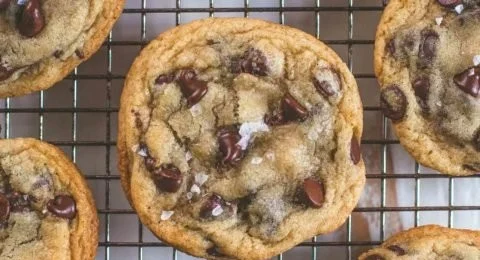 Freshly baked crispy and chewy chocolate chip cookies on a cooling rack.