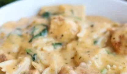 Bowl of creamy dairy-free chicken alfredo pasta topped with parsley.