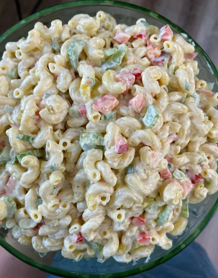 Delicious bowl of macaroni salad with vegetables and dressing