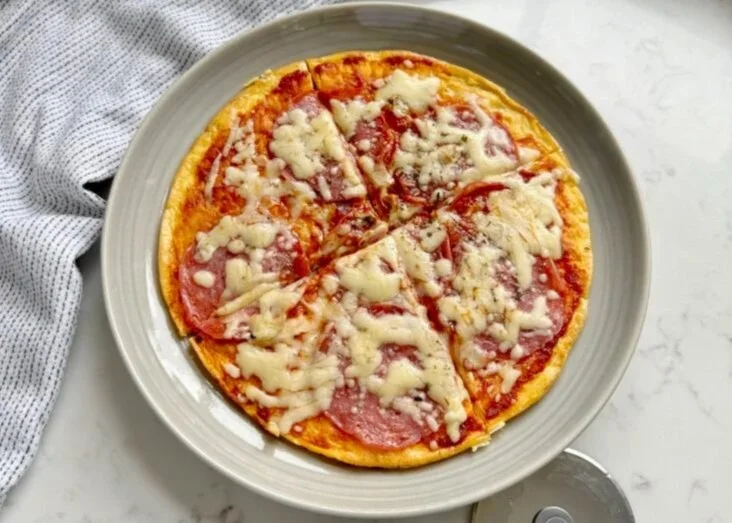 A vibrant plate of Pizza Eggs, featuring fluffy scrambled eggs topped with pepperoni and cheese.