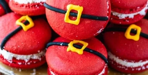 Festively decorated Santa Claus Macarons on a holiday-themed plate.