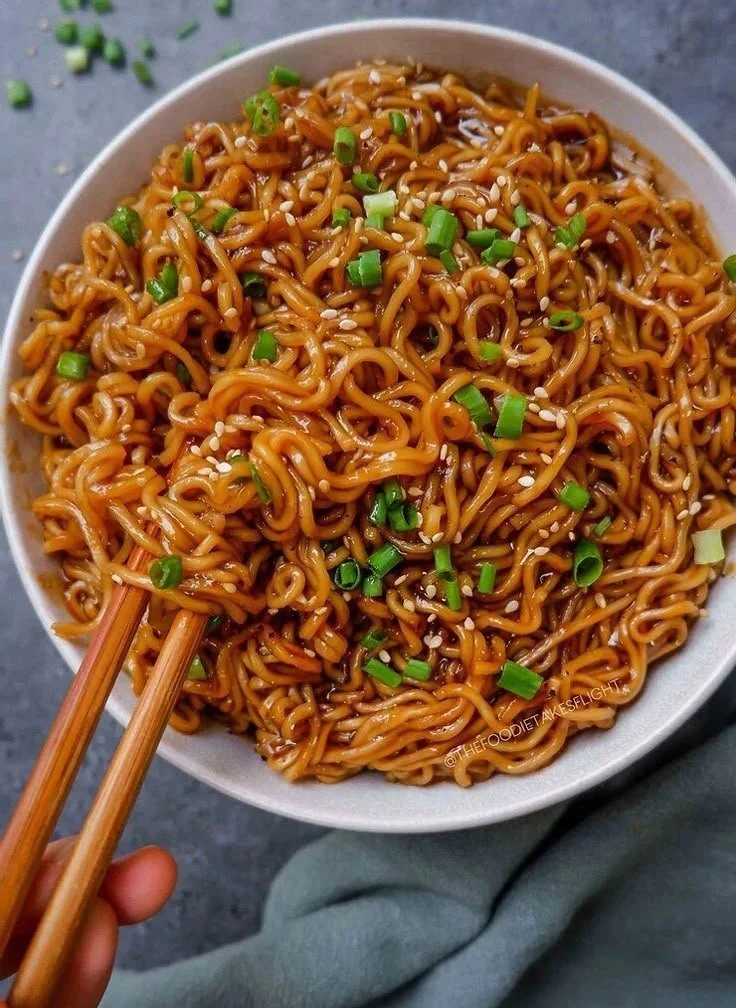 Delicious saucy ramen noodles served in a bowl with fresh toppings.