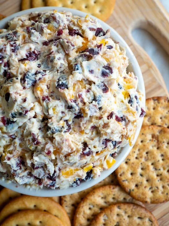 Tangy winter punch served in a festive glass with orange and cranberry garnishes.