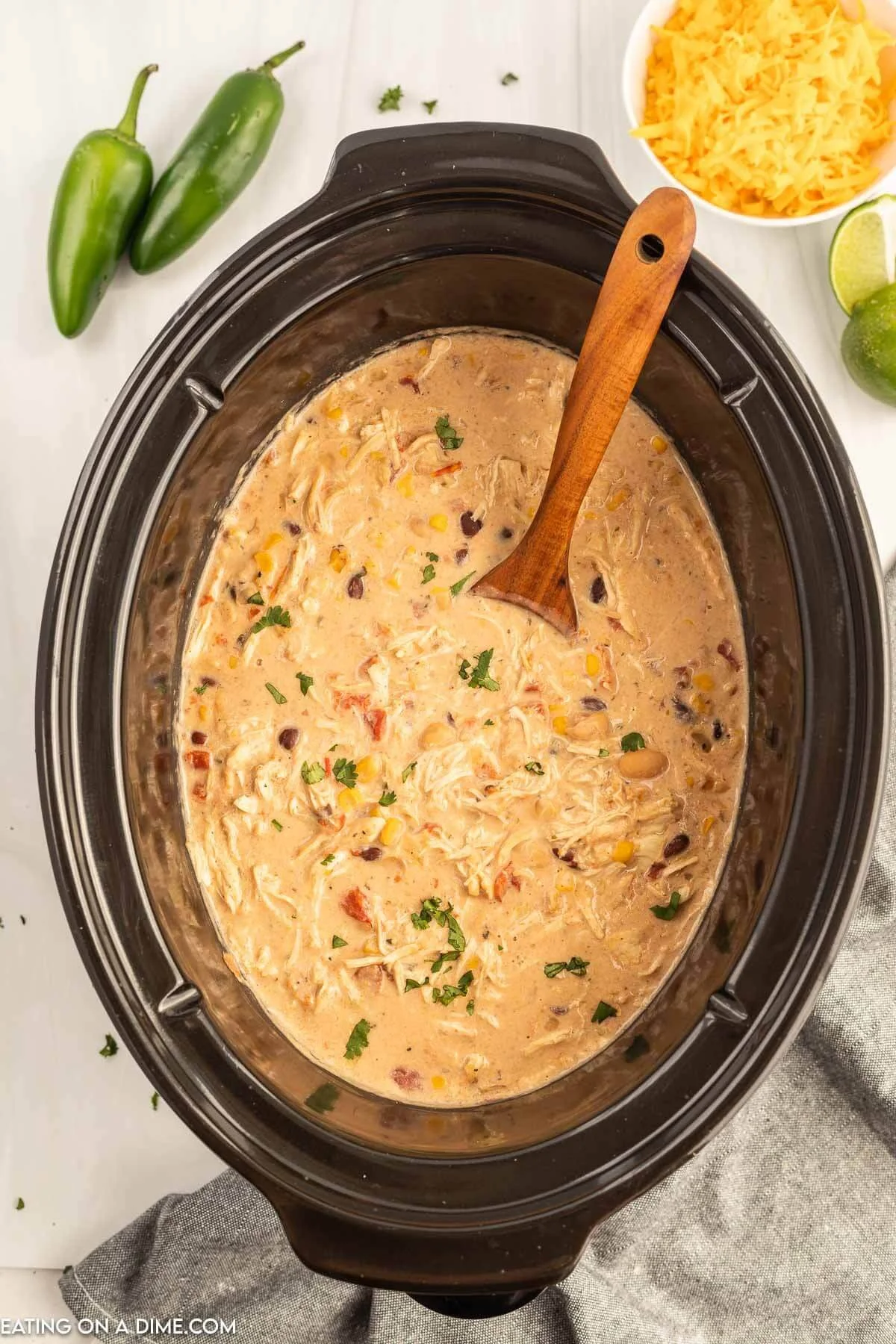 Bowl of Crock Pot Cream Cheese Chicken Chili topped with cheese and cilantro