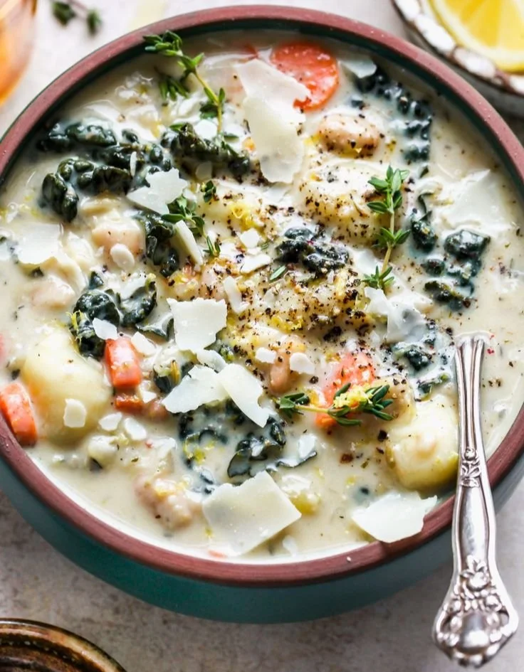 Bowl of Tuscan Creamy Gnocchi Soup topped with herbs and cream